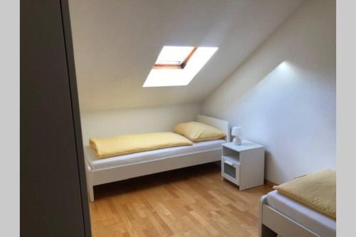 een kleine kamer met een bed en een dakraam bij Haus Altenburg in Innsbruck