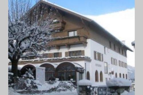 een met sneeuw bedekt gebouw met een boom ervoor bij Haus Altenburg in Innsbruck