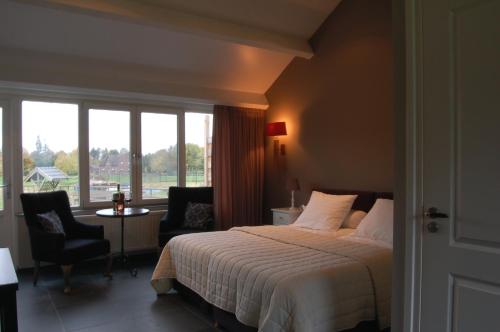 um quarto de hotel com uma cama e uma janela em B&B Roodbeekerhof em Vlodrop
