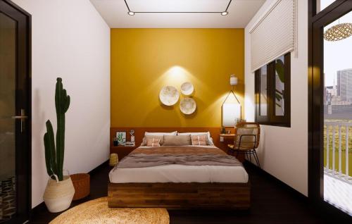 a bedroom with a bed and a yellow wall at Sun&Sea House Homestay in Quy Nhon