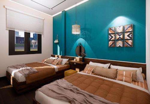 a bedroom with two beds and a blue wall at Sun&Sea House Homestay in Quy Nhon