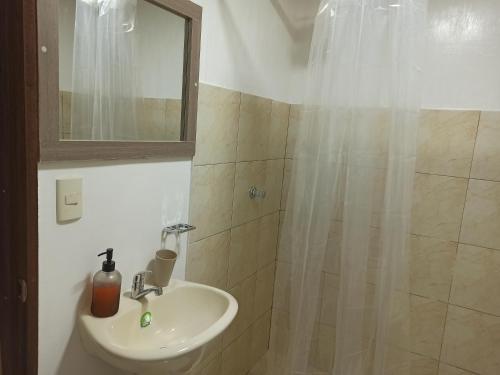 y baño con lavabo y ducha con espejo. en Habitaciones Alkimya, en Loja