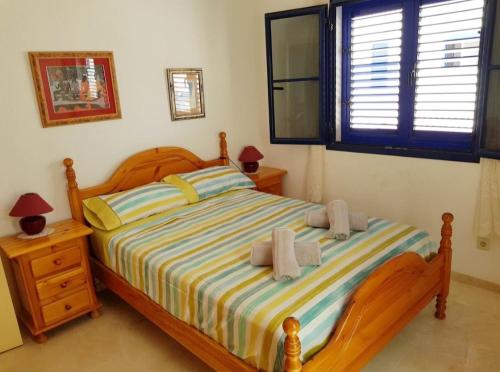 um quarto com uma cama de madeira e toalhas em Vivienda Agaete Paradise em Puerto de las Nieves