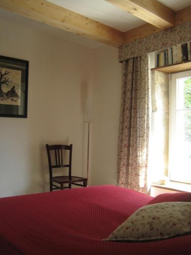 une chambre avec un lit, une fenêtre et une chaise dans l'établissement Bévau - B&B bio, à Trampot