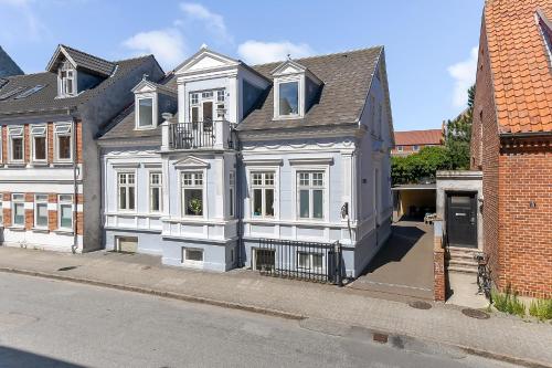 a large white house on the side of a street at Sweethome Guesthouse in Esbjerg