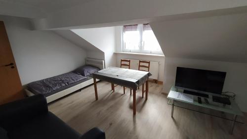 a small living room with a table and a tv at Wohnung Neunkirchen 3 in Neunkirchen am Brand
