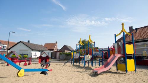 a playground with a bunch of playground equipment in the sand at Chaletparc Krabbenkreek Zeeland - Chalet 110 in Sint Annaland