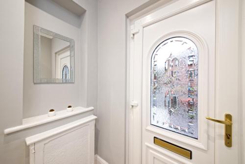a bathroom with a white door and a mirror at Beautiful Cozy Home With Free Parking in Manchester
