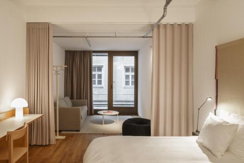 a hotel room with a bed and a living room at Haus im Tal in Munich