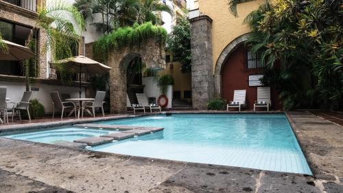 a swimming pool in front of a building at Hotel de Mendoza in Guadalajara