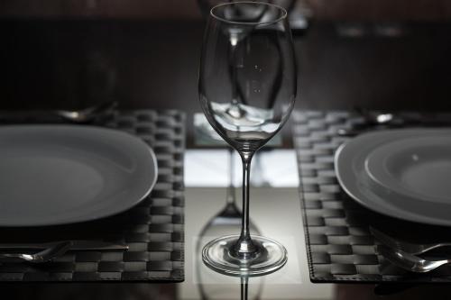 a wine glass sitting on a table next to a plate at Deluxe Jacuzzi Apartment by LIUKSAI in Klaipėda