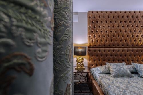 a bedroom with a bed with a headboard and a lamp at Deluxe Jacuzzi Apartment by LIUKSAI in Klaipėda