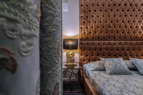 a bedroom with a bed with a headboard and a lamp at Deluxe Jacuzzi Apartment by LIUKSAI in Klaipėda