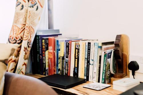 a book shelf with a bunch of books on it at The Stable at Ty Beic in Bala