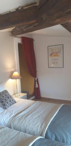 a bedroom with a large bed with a red curtain at La Maison Des Autres, piscine chauffée, chambres d'hôtes proches Uzès, Nîmes, Pont du Gard in Saint-Géniès-de-Malgoirès