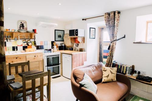 a living room with a couch and a kitchen at The Stable at Ty Beic in Bala