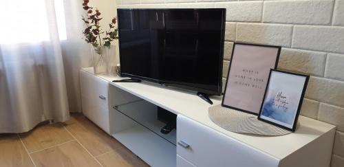 a flat screen tv sitting on top of a white desk at Lovely Private Flats FREE parking in Novi Sad