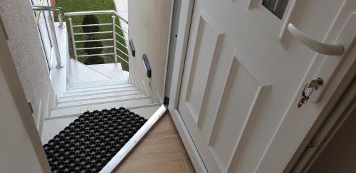 an open door with a black and white stair case at Lovely Private Flats FREE parking in Novi Sad