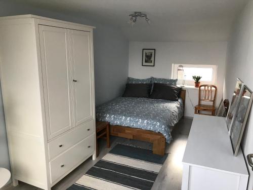 a bedroom with a bed and a white cabinet at Vaals Suite Apartment in Vaals