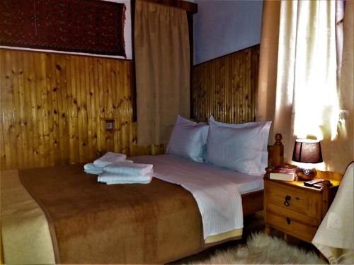 a bedroom with a bed with towels on it at Hotel Acropolis Metsovo in Metsovo