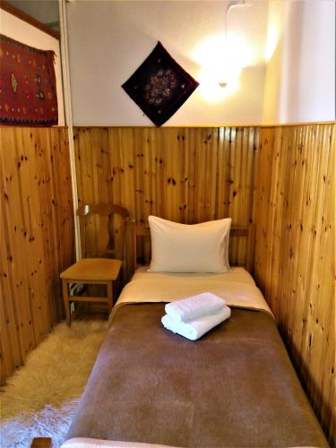 a bedroom with a bed and a chair in it at Hotel Acropolis Metsovo in Metsovo