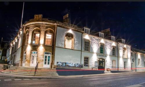a large white building with lights on it at The Seafield Arms-Cullen in Cullen