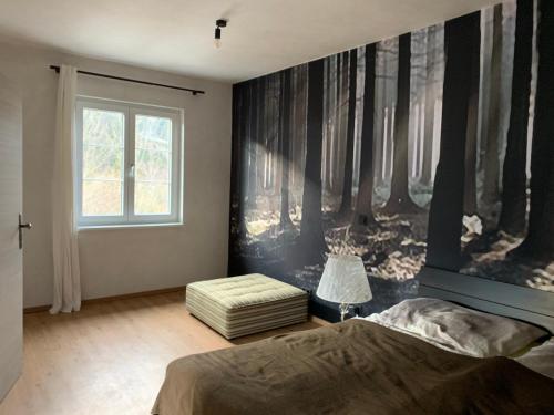 Bergchalet Hinterstoder في هينترستودر: غرفة نوم عليها لوحة اشجار على الحائط