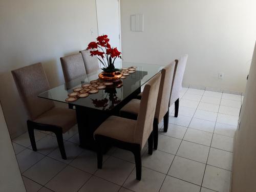una mesa de comedor con sillas y un jarrón de flores en Condomínio Residencial Serigy, en Aracaju
