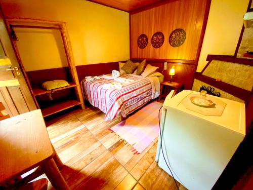 a small bedroom with a bed and a mirror at Pousada Magia da Montanha in Visconde De Maua