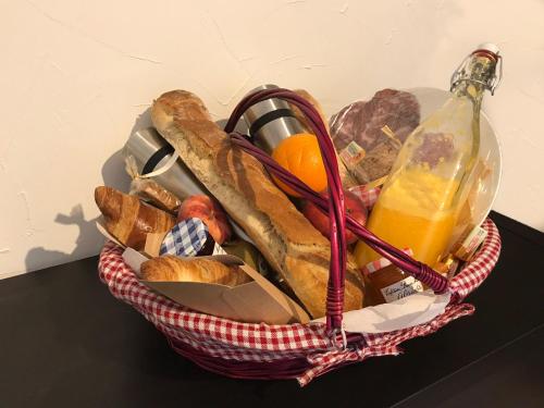 ein Korb gefüllt mit Brot und einem Orangensaft in der Unterkunft Le Clos des Arbousiers in Linguizzetta