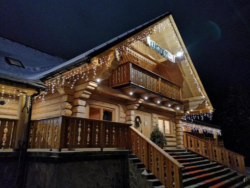a house with christmas lights on the stairs at Olza Karczma i pokoje in Istebna