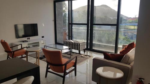 a living room with a couch and chairs and a tv at One Rodney Heights Condominiums in Gros Islet