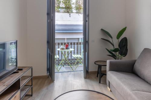 un soggiorno con divano e TV e un balcone di Balmis Plaza Apartments ad Alicante