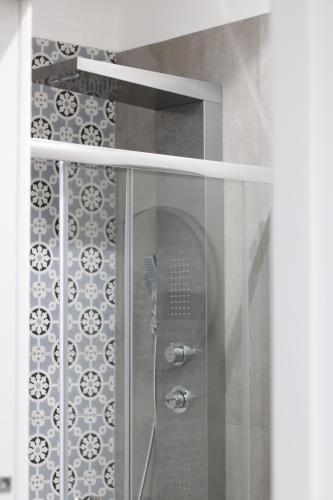 una ducha en un baño con puerta de cristal en Solli Rooms, en Palermo
