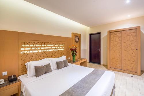 a bedroom with a large white bed and a wooden door at Al Muhaidb Al Malaz - Al Jamiah in Riyadh