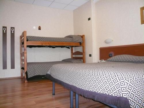 a bedroom with two bunk beds and a wooden floor at Albergo Belvedere in Scanno