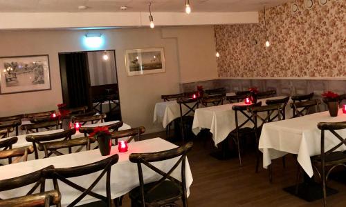 a dining room with tables and chairs with red candles at Baren i Ockelbo in Ockelbo