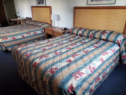 a hotel room with two beds with a colorful bedspread at Apple Tree Inn in Spokane