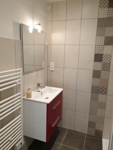 a bathroom with a white sink and a mirror at RAND'UBAYE in Barcelonnette