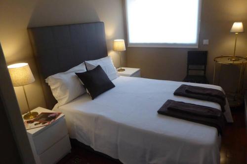 - une chambre avec un grand lit blanc et 2 oreillers dans l'établissement Luminous Central Apartment, à Porto