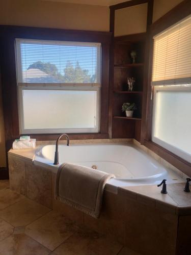 y baño con bañera grande y 2 ventanas. en Shorelight Inn, en Benicia