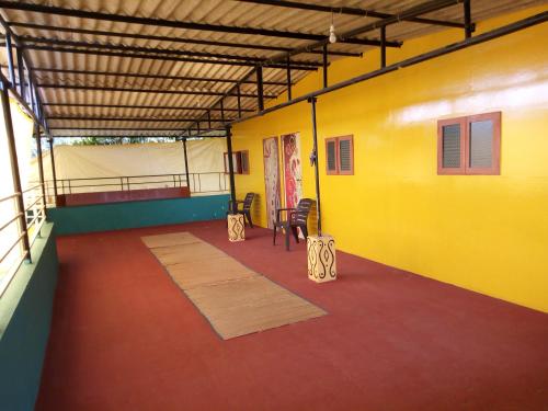 una camera con una parete gialla e un tavolo con sedie di Sachin homestay a Mandrem