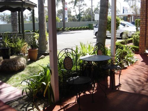 a patio with a table and chairs and plants at Avaleen Lodge Motor Inn in Nowra