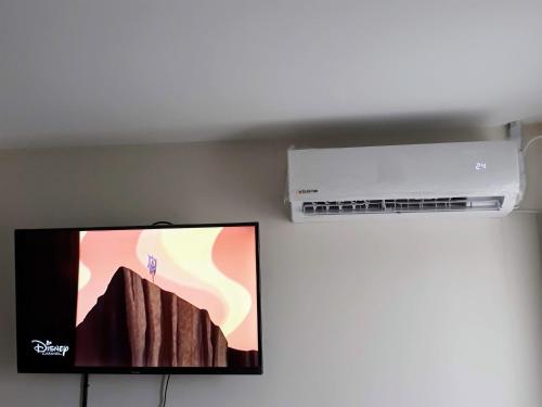 TV de pantalla plana colgada en una pared junto a un compresor de aire en Cómodo y versátil en casco histórico en Salta