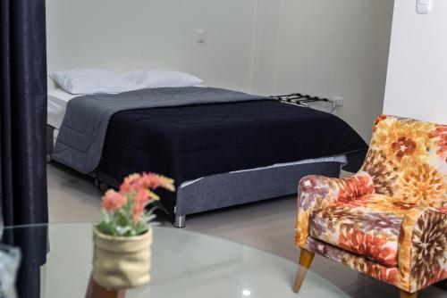 a bedroom with a bed and a chair at MiniApartamentos GRAN IMPERIAL PREMIUM in Tumbes