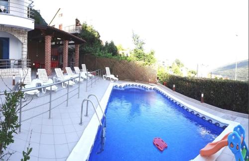uma grande piscina com cadeiras e uma piscina em Villa Sea-N-Sun, 7 bedrooms & Pool, nearby Portonovi Marina. em Ðenovići