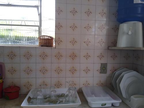 a kitchen with a sink and a tiled wall at POUSADA DO JOAO in Juiz de Fora