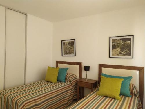 1 dormitorio con 2 camas y mesa con lámpara en Departamento Los Jazmines en Tandil