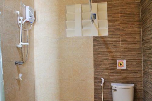 a bathroom with a shower and a toilet in it at Deep Forest Garden Hotel in Puerto Princesa City