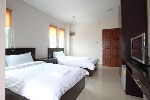 a bedroom with two beds and a television in it at Garden Hill Hotel in Trang